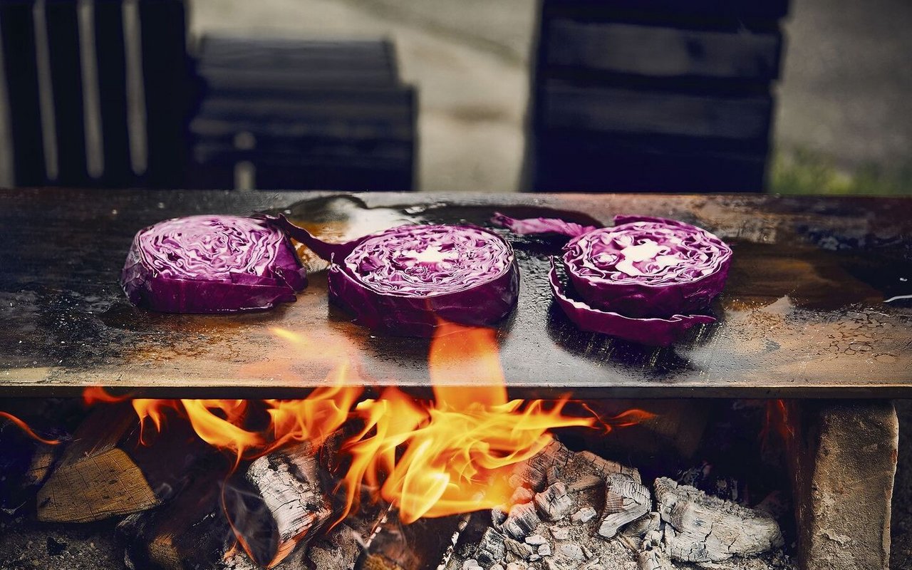 Es muss nicht immer eine Wurst und der Grillrost sein. Auch Gemüse eignet sich hervorragend zum Feuerkochen, zum Beispiel in dicke Scheiben geschnittener Chabis. 