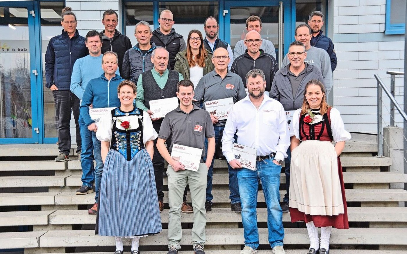 Nicolas Berger (hinten links) und Ronny Schweizer (hinten rechts) von Swissherdbook mit dem Präsidenten von Swissherdbook Solothurn, Daniel Schluep (hinten 3. v. r.), mit den Ehrendamen und den geehrten Züchter(innen) der 100 000er-Kühe.  
