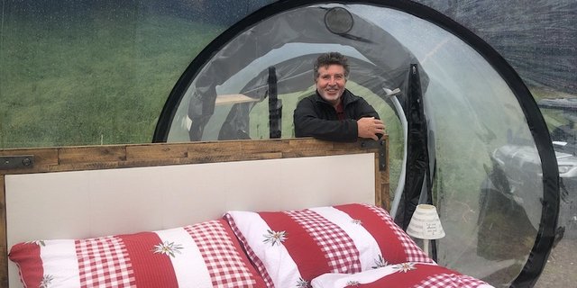 Heinz Egli in der Alpenbubble. Dank der transparenten Hülle hat man das Gefühl vom Schlafen unter freiem Himmel, wird aber bei Regen nicht nass. (Bild Esther Thalmann)