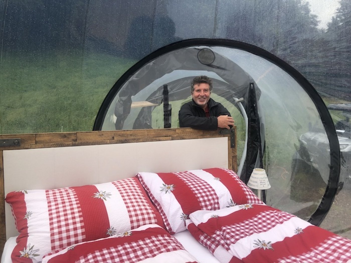 Heinz Egli in der Alpenbubble. Dank der transparenten Hülle hat man das Gefühl vom Schlafen unter freiem Himmel, wird aber bei Regen nicht nass. (Bild Esther Thalmann)