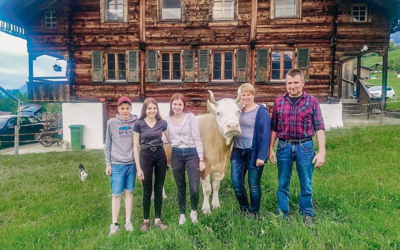 Tanja und Abraham Aellig mit den Kindern Martina, Ursina und Andrin. An der Halfter die Kuh Stella.