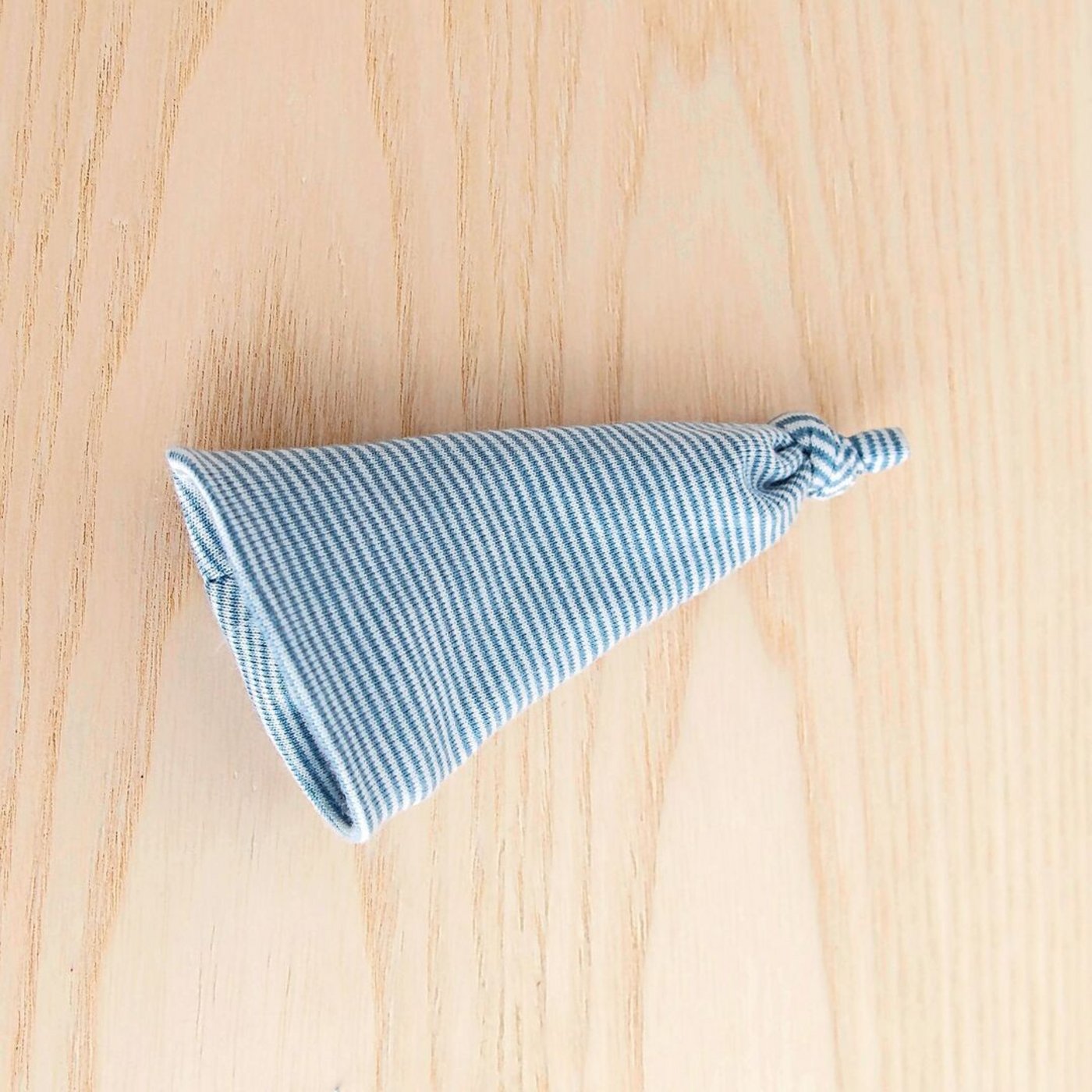 Die Mütze wenden, den Zipfel verknoten und den unteren Rand umkrempeln.