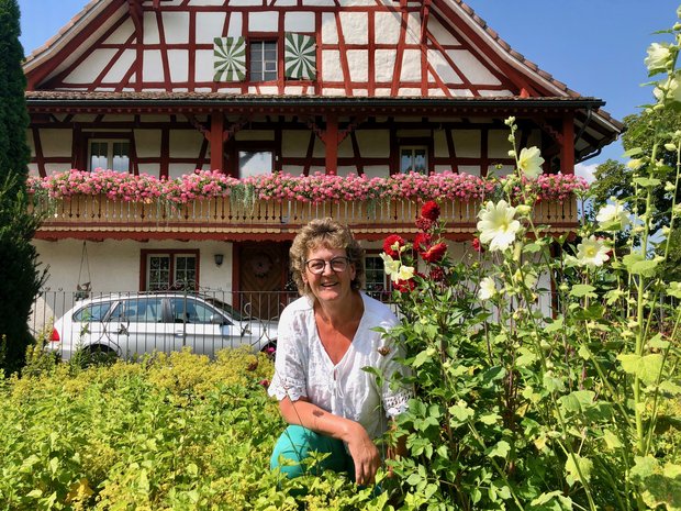 Ihre Blumen sind für sie eine Quelle der Kraft: Huguette Schwager vor dem Bauernhaus, das um 1760 als Teil des Klosters Tänikon gebaut wurde. Seit 1828 lebt die Familie Schwager darin. (Bild Jeanne Woodtli)