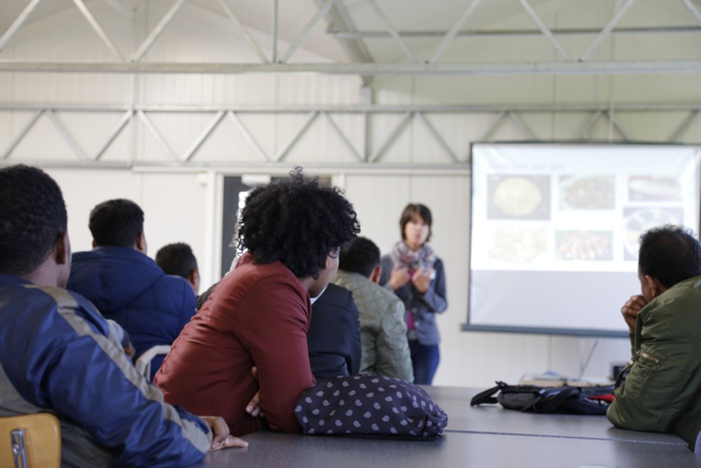 Aufmerksam hören die Flüchtlinge Karin Oesch zu, als sie von den Arbeitsbedingungen in der Schweizer Landwirtschaft erzählt.