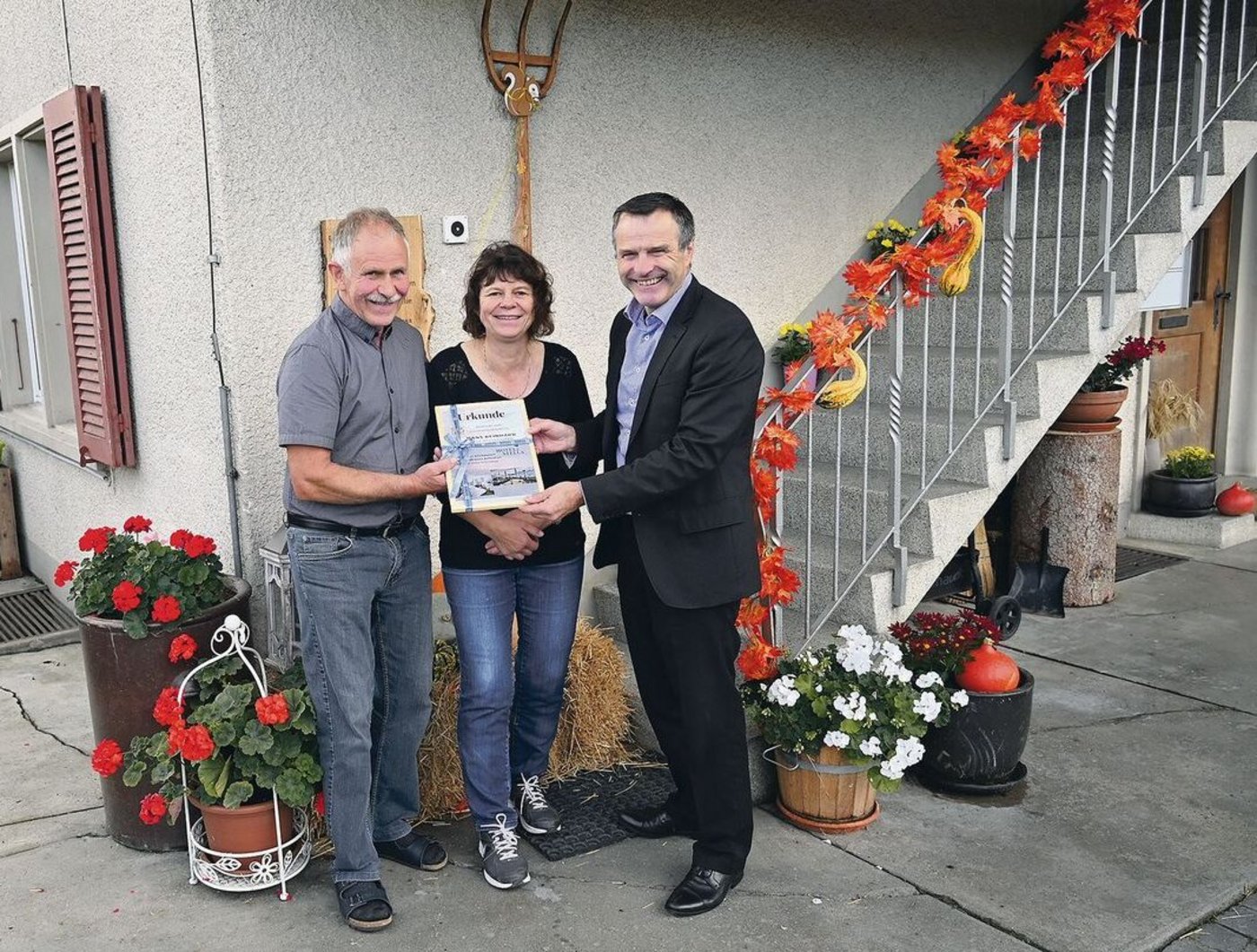 Urs Schneider (rechts) übergibt den Hauptpreis, eine Reise nach Wahl, symbolisch an Hans und Sonja Reinhard.