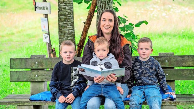 Sahra Brun-von Flüe mit ihren drei Buben (v. l.) Noah (6,5), Fabio (2,5) und Dario (4,5) am Büechli lesen beim Start des Themenweges bei der Bohrplatte Finsterwald.