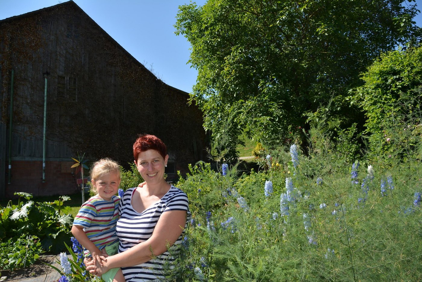Monika Kurmann mit ihrer Tochter Maila im Garten mit den prächtigen Blumen und verschiedenem Gemüse. (Bild Franziska Jurt)