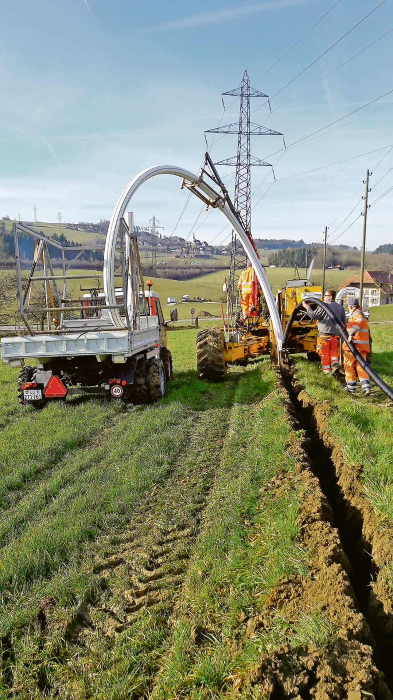 Am Kabelpflug ist ein Verlegeschacht angehängt, mit dem die Rohrleitung in die Grabensohle gelegt wird. 