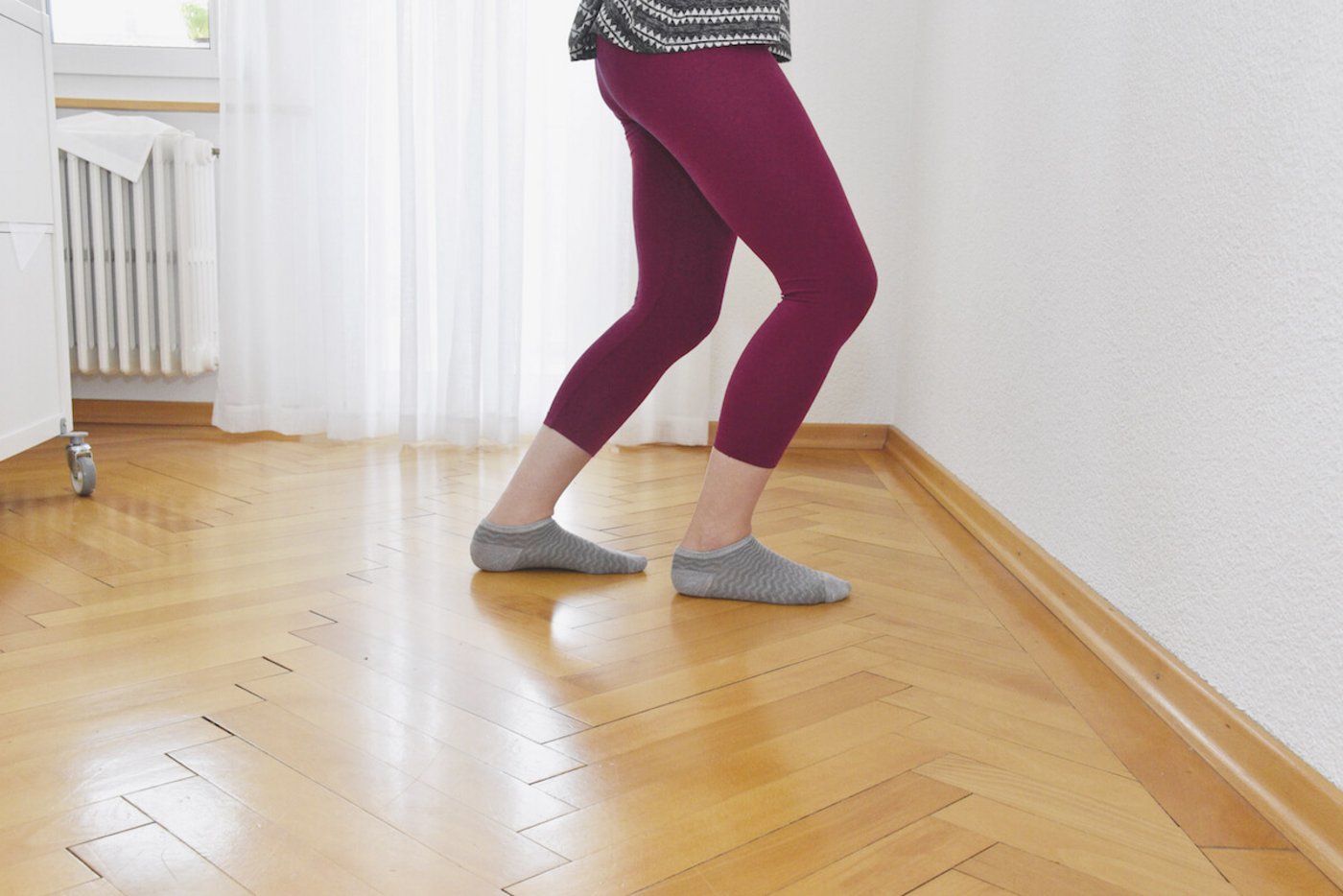 Ferse und Wade dehnen: Einen Fuss vor den anderen stellen. Darauf achten, dass sie parallel stehen. Beide Knie beugen, ohne die Ferse anzuheben. Zehn Sekunden halten und wechseln. 20 Wiederholungen. (Foto: Cornelia von Däniken)