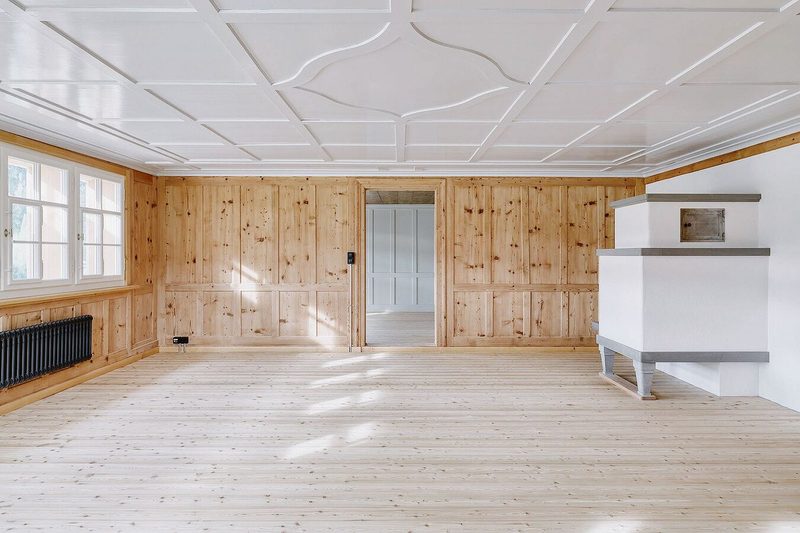 In der Stube setzen dezente, traditionelle Farbtöne einen Kontrast zu den Holzoberflächen in den restlichen Räumen.