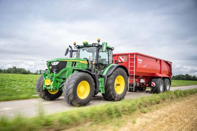 Der John Deere 6R Traktor mit Anhänger.