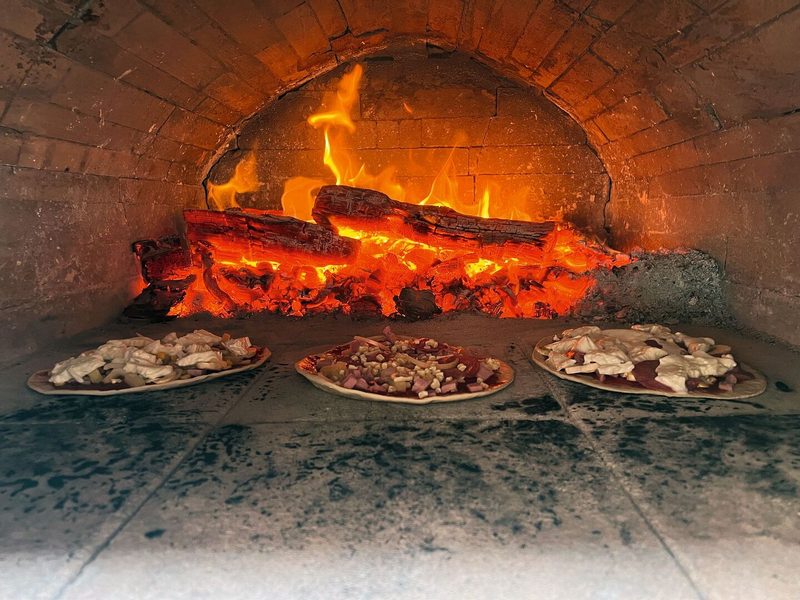 Pizze werden im Holzofen gebacken.