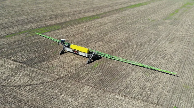 Nexat führt den Pflanzenschutz aus, indem das System mit einer enorm breiten Spritze über das Feld fährt.