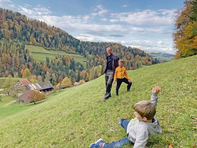 «Schau, wie steil es ist», sagt Josias und demonstriert das mit Purzelbäumen am Hang. Hinten: Jakob Wickli mit Sohn Aaron (Frau Lucienne, Tocher Annalena und Sohn Linard fehlen).