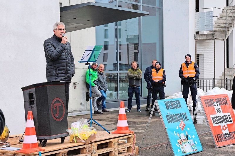 Christian Hofer, Direktor des Bundesamts für Landwirtschaft, spricht zu den Landwirten vor dem Eingang des BLW, der von Polizisten bewacht wird.