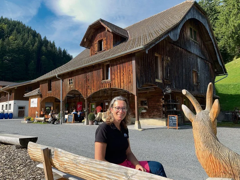 Mitinhaberin Antonia Treskatsch Schmid vor dem zur Besenbeiz umgebauten alten Stall auf dem Blüemlisberg. Links die neue Scheune für die Ziegen und für die Milchverarbeitung.
