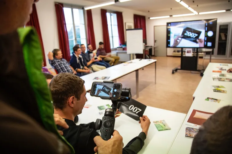 Olivier Boillat zeigt der ganzen Betriebsleiter-Klasse, welchen Flyer sein Schüler im Marketing-Unterricht analysiert. Bild: Pia Neuenschwander