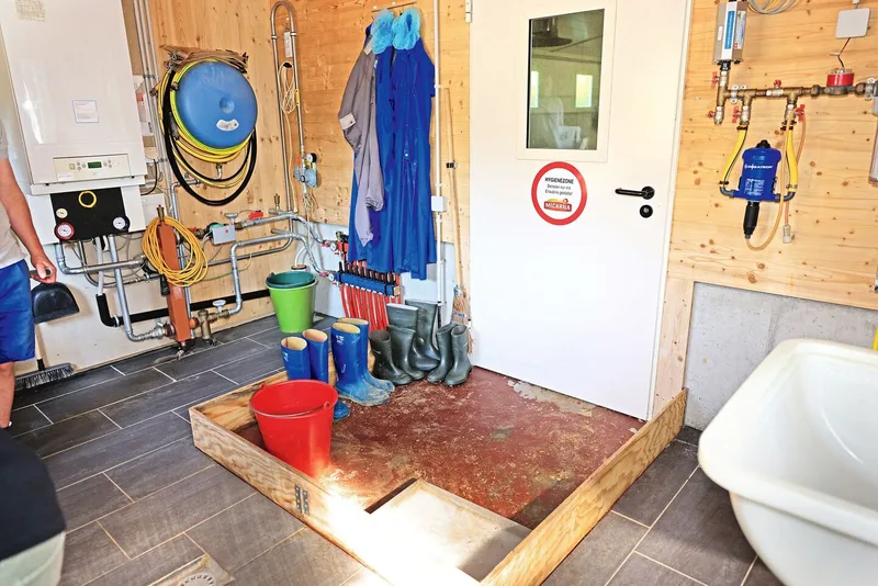 Die Hygieneschleuse wird gezeigt: Vor der inneren Stalltüre gibt es einen mit Fussleisten abgetrennten Bereich, in dem auch das Schuhdesinfektionsbad steht.
