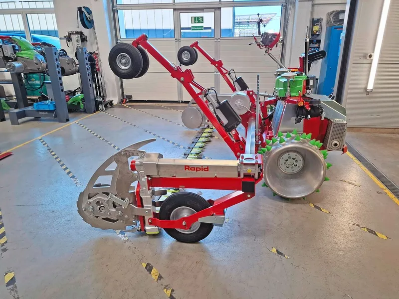 Der Mähbalken wird über Tasträder geführt. Beim Wenden läuft die Maschine auf den Schwenkrädern am hier angehobenen Gestänge. Diese machen die Maschine auch beim Auf- und Ablad manövrierfähig.