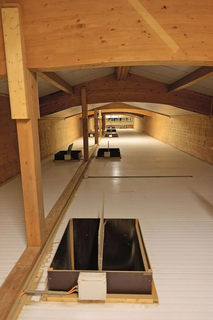 Durch die Luken im Boden gelangt die Luft aus dem Stall hinauf in den Abluftkanal. Hinten ist der Luftwäscher zu erkennen.