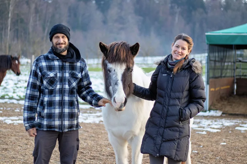 Thomas Reinhard und Fabienne Meier stehen mit ihrem Pferd Njola auf der grosszügigen Anlage des Naturhofes Waltwil4.