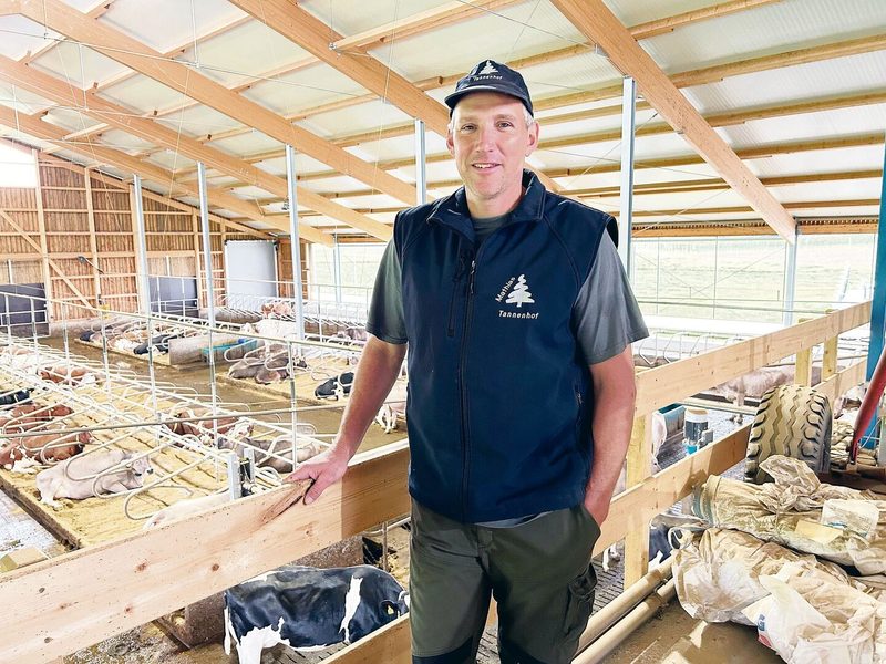 Mathias Roth erklärt sein Stallbaukonzept mit 120 Stallplätzen. Es besteht aus sechs Reihen Liegeboxen. Die zwei Fressachsen befinden sich an den Aussenseiten. Die Stallgänge reinigt ein Entmistungsroboter.