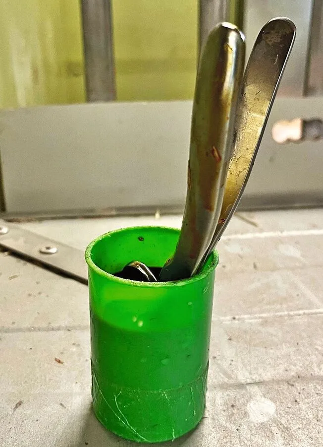In einem grünen Plastikbecher ist der Emaskulator gelagert.
