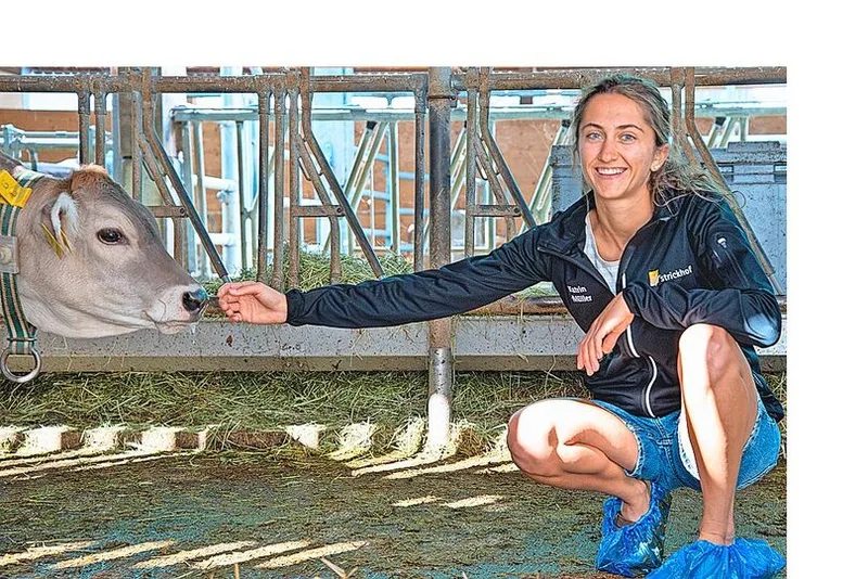 Katrin Müller kniet sich neben ein Kalb.