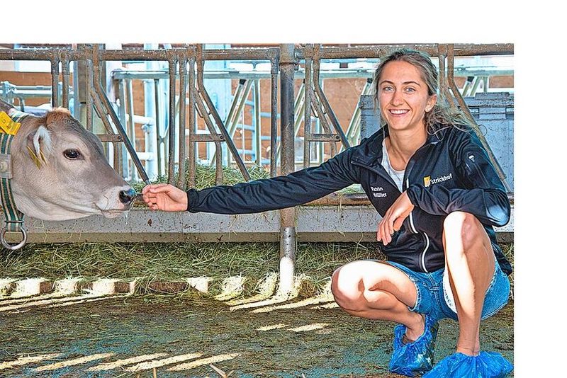 Katrin Müller kniet sich neben ein Kalb.