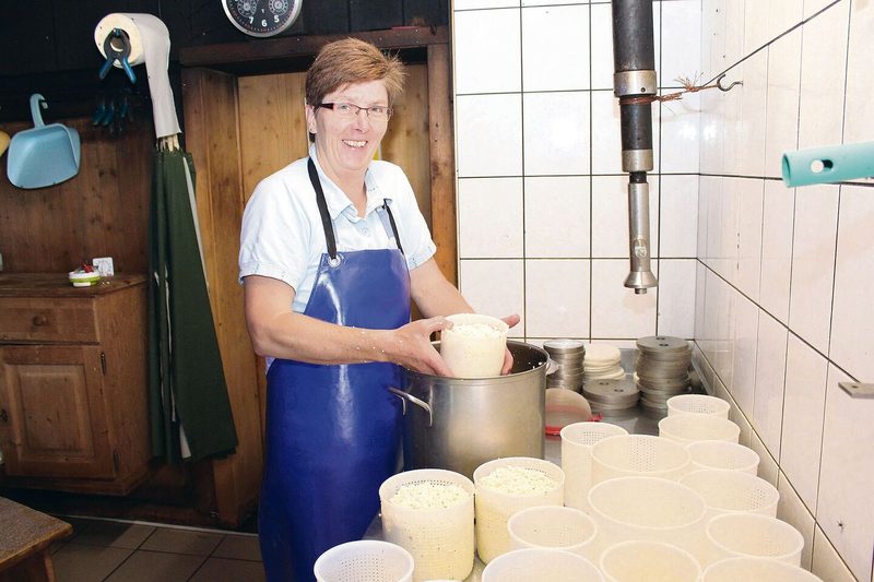 Bernadette Brunner füllt die fertige Käsemasse in die entsprechenden Formen. Dabei gibt sie Gewürze bei.