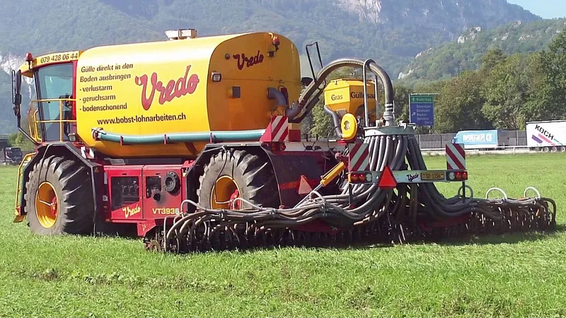 Ein selbstfahrendes Güllefass hat ein Sägerät aufgebaut und fährt damit über das Feld.