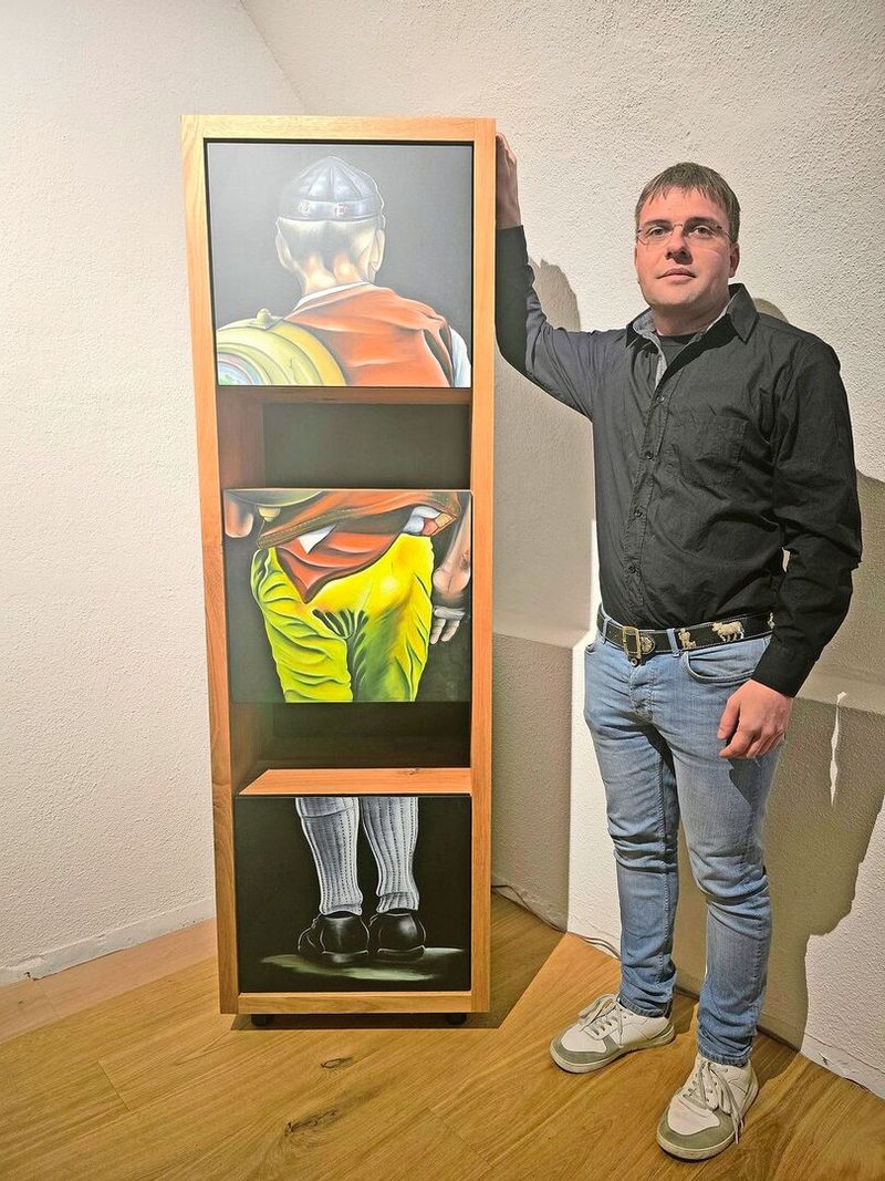 Ein Appenzeller Senn in der typischen gelben Hose ziert dieses Regal. Trachten und ihre Details sind ein beliebtes Motiv von Stefan Manser.