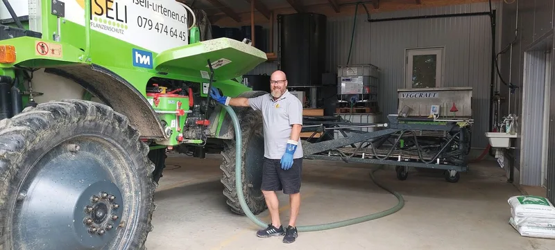 Stefan Iseli ist sehr zufrieden mit der Aktivkohle-Reinigungsanlage. Mit dem Schlauch kann er das Waschwasser einfach von der Feldspritze in den Tank im Boden pumpen.