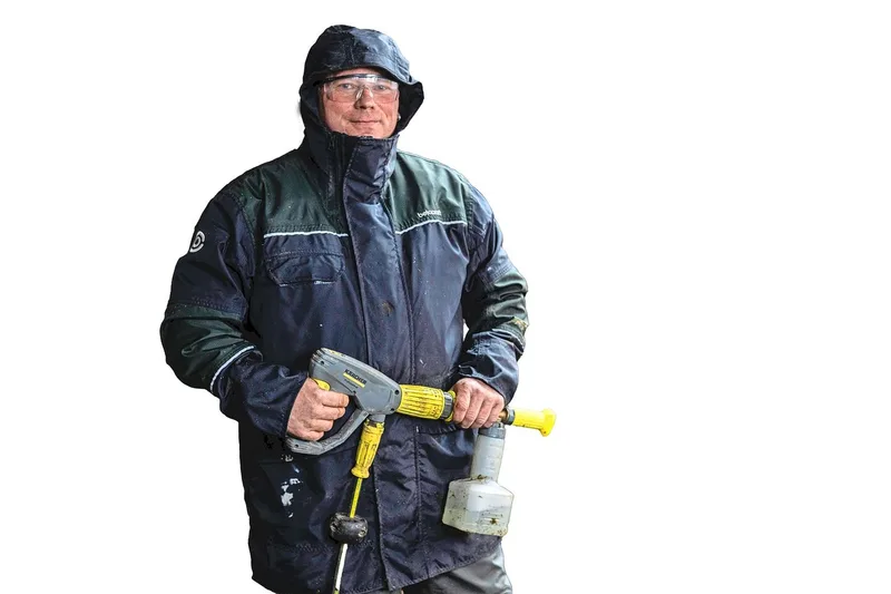 Schutzbrille, Kapuze, wasserfeste Kleidung und Gummistiefel: Martin Abderhalden ist bereit für die Stallreinigung.
