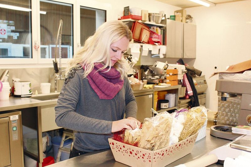 Corina Krauer bestückt einen Geschenkkorb. Im Hofladen sind Handarbeit und Liebe zum Detail gefragt.