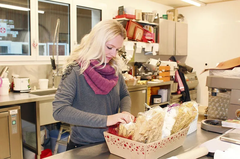 Corina Krauer bestückt einen Geschenkkorb. Im Hofladen sind Handarbeit und Liebe zum Detail gefragt.