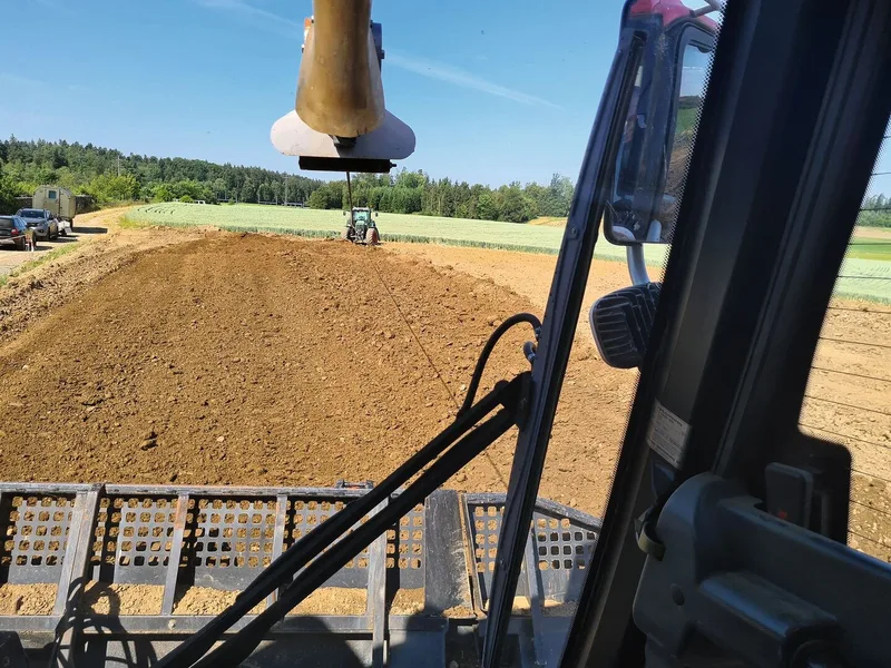 Am Traktor ist die Seilwinde verankert. Die Winde verbessert die Schubkraft, indem durch den Zug am Seil die Raupenauflage optimiert wird.