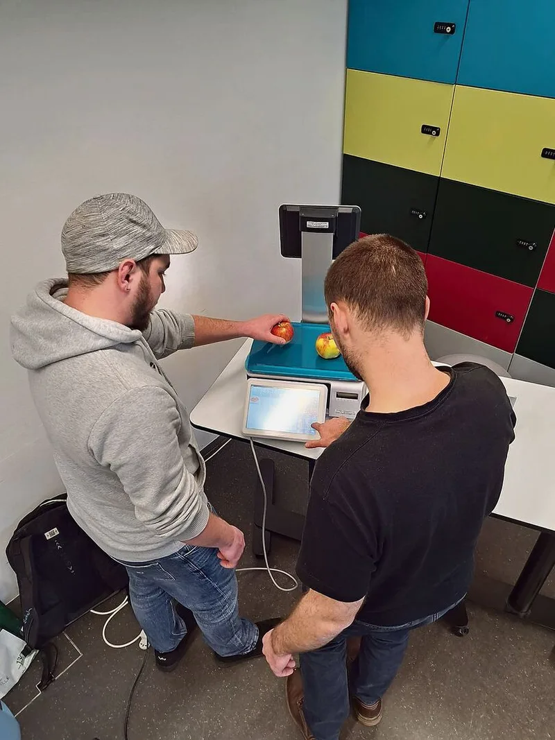 Silvan Schönholzer und Florian Mennet testen die Swiss-Waage. Mit dem Touchscreen können sie die Preise anpassen.