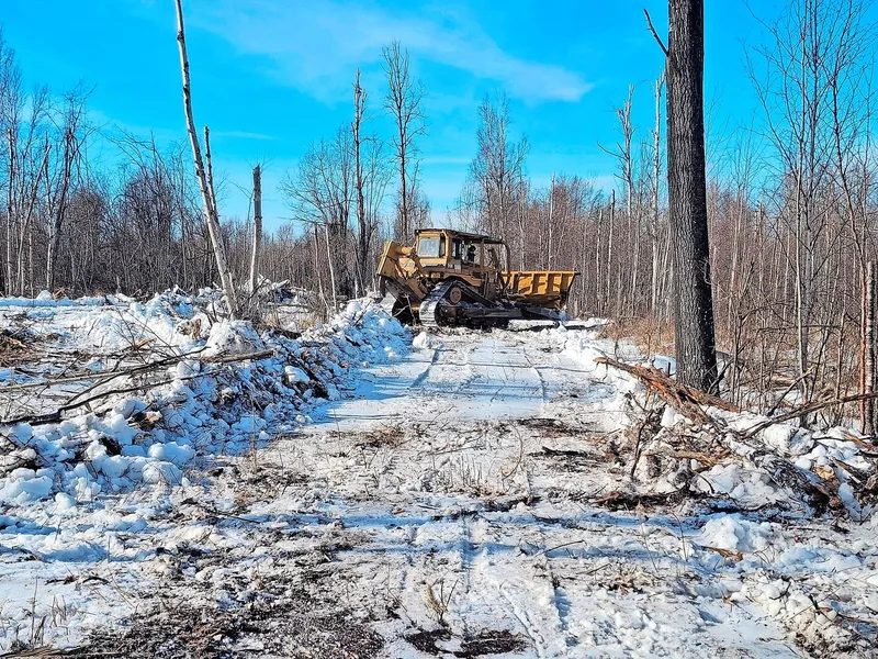 Der Lohnunternehmer mit dem Bulldozer hat Freude am neu zugekauften Land, gibt es doch dort auch noch einiges zu roden.