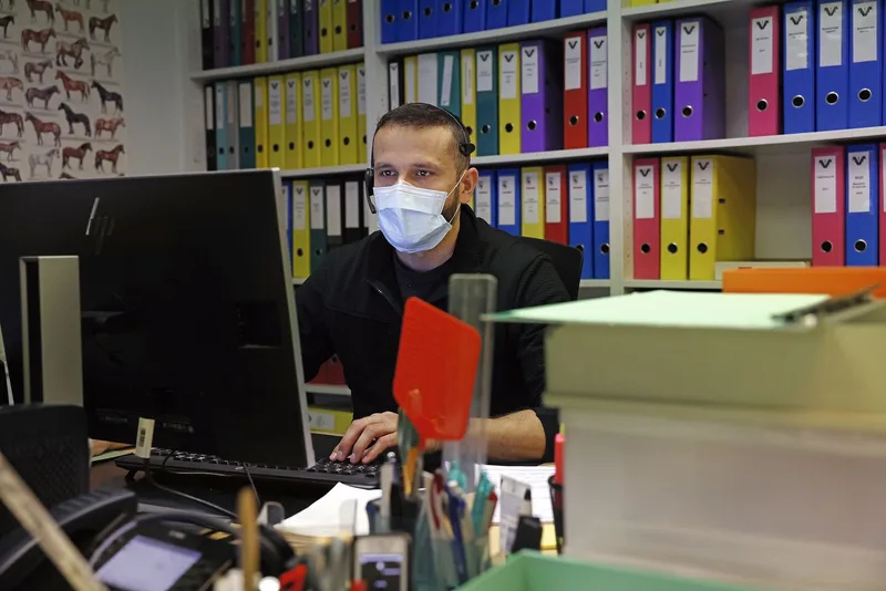 Martin Blaser sitzt im Büro, trägt Kopfhörer und telefoniert mit Kunden.