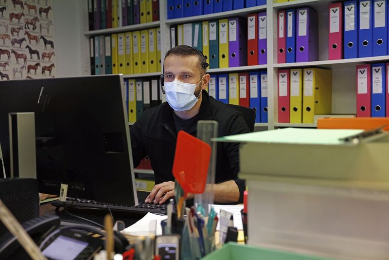 Martin Blaser sitzt im Büro, trägt Kopfhörer und telefoniert mit Kunden.
