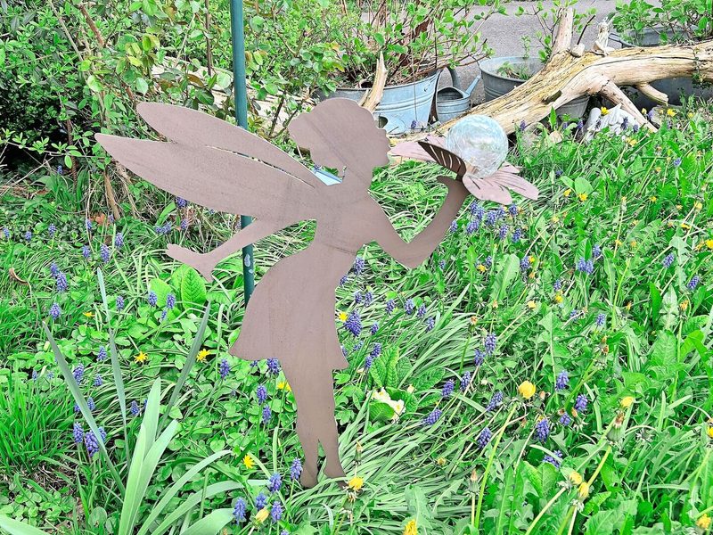 Verspielte Elemente: An verschiedenen Orten im Garten zieren Elfenfiguren die Töpfe oder Beete.