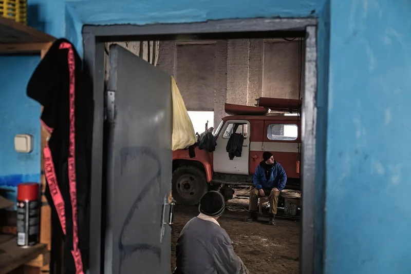 Arbeiter der Agromol-Milchfarm in einem zerstörten Stall.