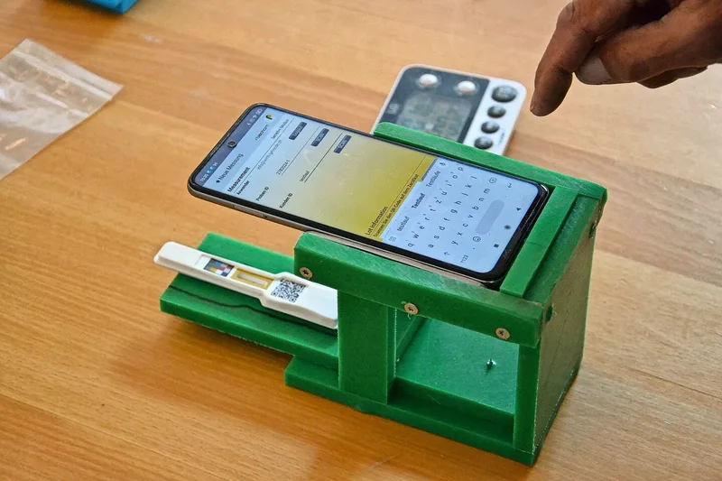 Die Distanz zwischen Smartphone und DON-Test beeinflusst das Ergebnis der Messung. Das grüne Gestell sorgt für einen einheitlichen Abstand.