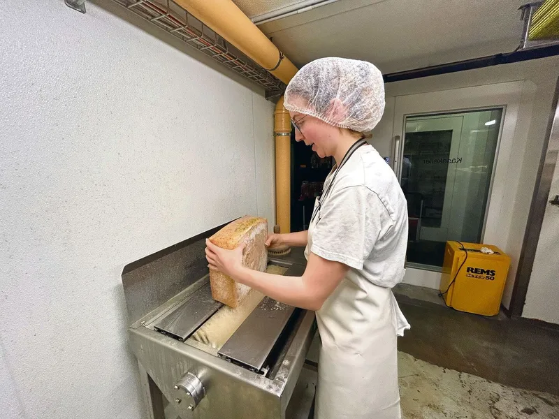 Regelmässig schmiert Sophie Bührer die Käse mit der Käseschmiermaschine. Das gehört zum Reifungsprozess und begünstigt die Verhärtung der Rinde.