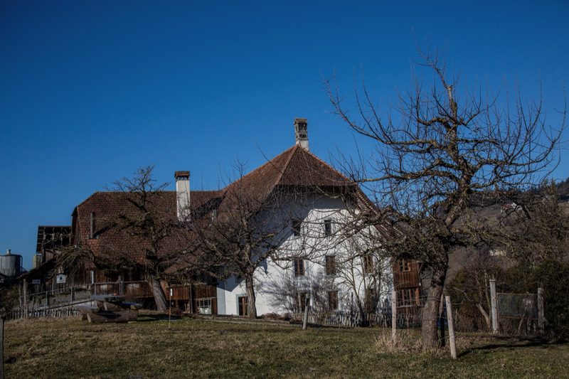 Das denkmalgeschützte Haus der Muriboden-Hofs ist weiss getüncht, mit tiefem Dach und Fenstern, die für die Region ungewohnt keine Fensterläden haben. Bild: Pia Neuenschwander