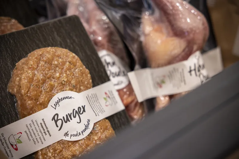 Nahaufnahme eines Burgers, eingeschweisst und mit einem Kleber, der ausweist, dass es sich um Althennenfleisch handelt..